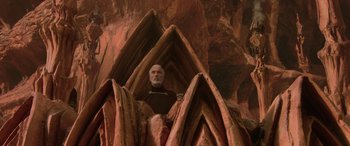 Movie still from “Star Wars: Episode II - Attack of the Clones” (2002), directed by George Lucas – An old man sitting in the middle of a cave; Wide shot, Overhead angle