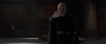 Movie still from “Star Wars: Episode II - Attack of the Clones” (2002), directed by George Lucas – An older man in a black robe and a red cape; Medium shot, Over the shoulder angle