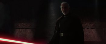 Movie still from “Star Wars: Episode II - Attack of the Clones” (2002), directed by George Lucas – An older man in a black shirt and a red cape; Medium shot, Over the shoulder angle