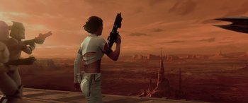 Movie still from “Star Wars: Episode II - Attack of the Clones” (2002), directed by George Lucas – A woman standing on a platform holding a gun in her hand; Wide shot, Low angle