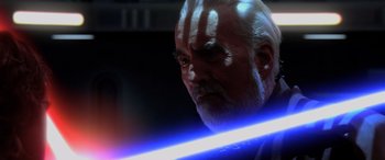 Movie still from “Star Wars: Episode III - Revenge of the Sith” (2005), directed by George Lucas – An old man with a long white beard holding a light saber; Close Up shot, Over the shoulder angle