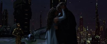 Movie still from “Star Wars: Episode III - Revenge of the Sith” (2005), directed by George Lucas – A man and a woman kissing in front of a building; Medium shot, Low angle