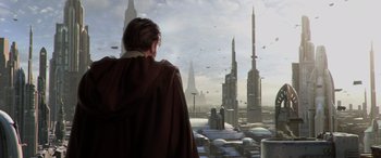 Movie still from “Star Wars: Episode III - Revenge of the Sith” (2005), directed by George Lucas – A man standing in front of a window looking out at a city; Wide shot, Low angle