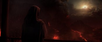 Movie still from “Star Wars: Episode III - Revenge of the Sith” (2005), directed by George Lucas – A person in a robe looking out at a large fire; Extreme Wide shot, Over the shoulder angle