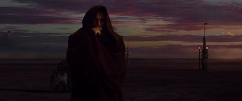 Movie still from “Star Wars: Episode III - Revenge of the Sith” (2005), directed by George Lucas – A man in a hooded cloak standing in front of a body of water; Medium shot, Low angle