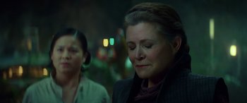 Movie still from “Star Wars: Episode IX - The Rise of Skywalker” (2019), directed by J.J. Abrams – A woman in a black jacket is looking down; Close Up shot, Over the shoulder angle
