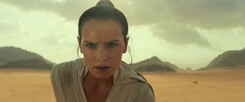 Movie still from “Star Wars: Episode IX - The Rise of Skywalker” (2019), directed by J.J. Abrams – A person in a field with mountains in the background; Close Up shot, Over the shoulder angle