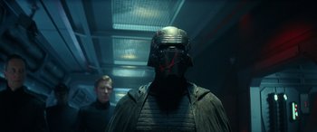 Movie still from “Star Wars: Episode IX - The Rise of Skywalker” (2019), directed by J.J. Abrams – A man wearing a helmet standing next to another man in a room; Close Up shot, Low angle