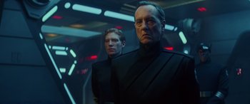 Movie still from “Star Wars: Episode IX - The Rise of Skywalker” (2019), directed by J.J. Abrams – Two men in black suits standing next to each other; Medium shot, Low angle