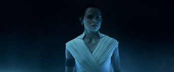 Movie still from “Star Wars: Episode IX - The Rise of Skywalker” (2019), directed by J.J. Abrams – A woman in a white shirt is standing in the dark; Close Up shot, Low angle
