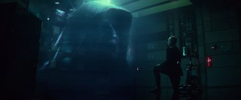 Movie still from “Star Wars: Episode IX - The Rise of Skywalker” (2019), directed by J.J. Abrams – A man sitting on a chair in front of a wall; Wide shot, Over the shoulder angle