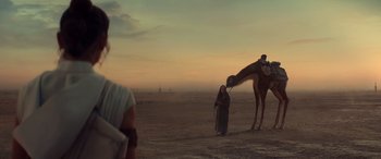 Movie still from “Star Wars: Episode IX - The Rise of Skywalker” (2019), directed by J.J. Abrams – A woman standing next to a camel on a dirt field; Extreme Wide shot, Low angle