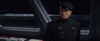 Movie still from “Star Wars: Episode VIII - The Last Jedi” (2017), directed by Rian Johnson – A man in a black uniform and a black hat; Close Up shot, Low angle