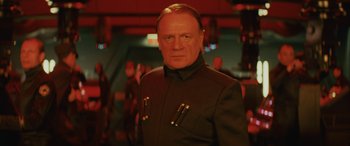 Movie still from “Star Wars: Episode VIII - The Last Jedi” (2017), directed by Rian Johnson – An older man in a black jacket is looking at the camera; Close Up shot, Low angle