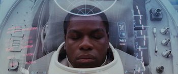 Movie still from “Star Wars: Episode VIII - The Last Jedi” (2017), directed by Rian Johnson – A man wearing a space suit with his eyes closed; Close Up shot, Overhead angle