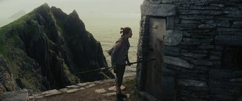 Movie still from “Star Wars: Episode VIII - The Last Jedi” (2017), directed by Rian Johnson – A woman standing on a cliff looking out at the ocean; Wide shot, Low angle
