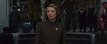 Movie still from “Star Wars: Episode VIII - The Last Jedi” (2017), directed by Rian Johnson – An older woman wearing a brown jacket and a red and white stripe on her chest; Close Up shot, Low angle