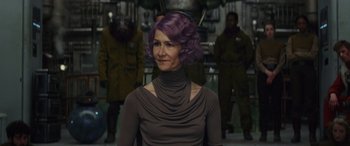 Movie still from “Star Wars: Episode VIII - The Last Jedi” (2017), directed by Rian Johnson – A woman with purple hair is standing in front of other people; Close Up shot, Over the shoulder angle