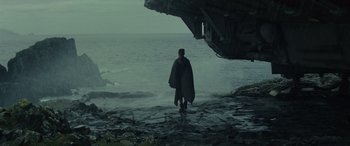 Movie still from “Star Wars: Episode VIII - The Last Jedi” (2017), directed by Rian Johnson – A man standing on the rocks near the water; Wide shot, Low angle