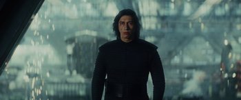 Movie still from “Star Wars: Episode VIII - The Last Jedi” (2017), directed by Rian Johnson – A man in a black outfit standing in front of a building; Medium shot, Low angle