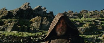 Movie still from “Star Wars: Episode VIII - The Last Jedi” (2017), directed by Rian Johnson – An older man with a beard wearing a hooded sweater; Close Up shot, Low angle