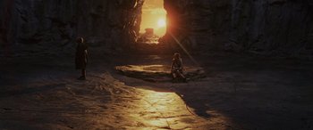 Movie still from “Star Wars: Episode VIII - The Last Jedi” (2017), directed by Rian Johnson – A person sitting on a rock in front of an entrance to a cave; Extreme Wide shot, High angle