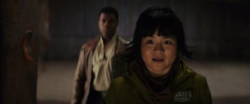 Movie still from “Star Wars: Episode VIII - The Last Jedi” (2017), directed by Rian Johnson – A young girl and a young man are standing in a dark room; Close Up shot, Over the shoulder angle