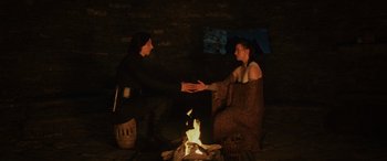 Movie still from “Star Wars: Episode VIII - The Last Jedi” (2017), directed by Rian Johnson – A man and a woman sitting in front of a fire; Medium shot, High angle