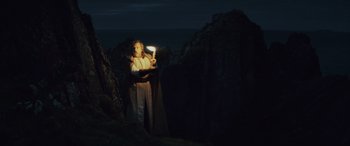 Movie still from “Star Wars: Episode VIII - The Last Jedi” (2017), directed by Rian Johnson – A person holding a candle in a dark place; Wide shot, Low angle