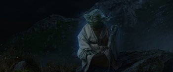 Movie still from “Star Wars: Episode VIII - The Last Jedi” (2017), directed by Rian Johnson – A statue of yoda sitting in the dark; Wide shot, Low angle