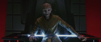 Movie still from “Star Wars: Episode VIII - The Last Jedi” (2017), directed by Rian Johnson – A man with a strange face is holding a light saber; Medium shot, Low angle