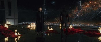 Movie still from “Star Wars: Episode VIII - The Last Jedi” (2017), directed by Rian Johnson – A man and a woman standing in front of a fire pit; Wide shot, High angle