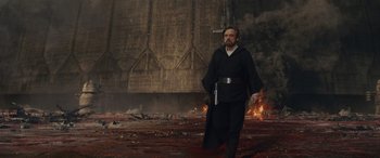 Movie still from “Star Wars: Episode VIII - The Last Jedi” (2017), directed by Rian Johnson – A man in black robe walking across a field of fire; Wide shot, Low angle