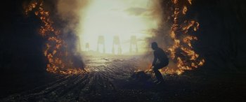 Movie still from “Star Wars: Episode VIII - The Last Jedi” (2017), directed by Rian Johnson – A man in a dirt field near a bunch of flames; Extreme Wide shot, Low angle