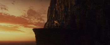 Movie still from “Star Wars: Episode VIII - The Last Jedi” (2017), directed by Rian Johnson – A woman sitting on a rock near a cliff; Extreme Wide shot, Low angle