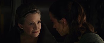 Movie still from “Star Wars: Episode VIII - The Last Jedi” (2017), directed by Rian Johnson – A woman is looking at another woman in a dark room; Close Up shot, Over the shoulder angle