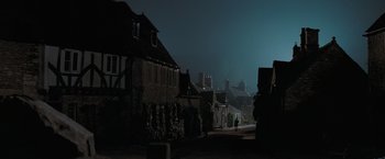 Movie still from “Stardust” (2007), directed by Matthew Vaughn – A person walking down a street at night; Extreme Wide shot, Low angle