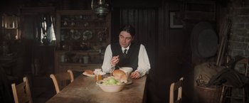 Movie still from “Stardust” (2007), directed by Matthew Vaughn – A man sitting at a table with a bowl of food; Medium shot, High angle