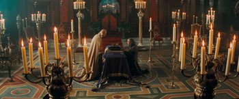 Movie still from “Stardust” (2007), directed by Matthew Vaughn – Two men sitting at a table with candles in a room; Wide shot, High angle