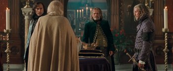 Movie still from “Stardust” (2007), directed by Matthew Vaughn – A man in a green jacket standing in front of a table; Medium shot, Over the shoulder angle