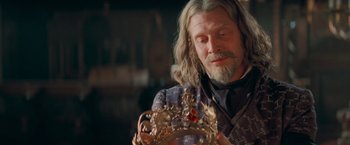 Movie still from “Stardust” (2007), directed by Matthew Vaughn – A man with long white hair and a beard holding a crown; Close Up shot, Over the shoulder angle