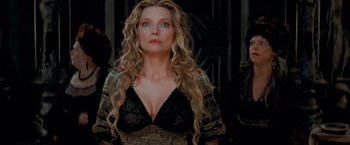 Movie still from “Stardust” (2007), directed by Matthew Vaughn – A woman with long blonde hair wearing a black and gold dress; Close Up shot, Over the shoulder angle
