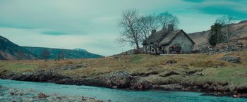 Movie still from “Stardust” (2007), directed by Matthew Vaughn – A house sitting next to a body of water; Extreme Wide shot, Low angle