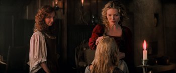 Movie still from “Stardust” (2007), directed by Matthew Vaughn – A woman in a red dress is combing a blonde girl's hair; Medium shot, Over the shoulder angle