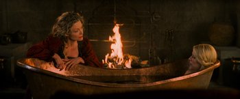 Movie still from “Stardust” (2007), directed by Matthew Vaughn – A woman sitting in front of an open fireplace; Medium shot, High angle