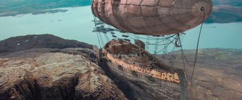 Movie still from “Stardust” (2007), directed by Matthew Vaughn – An old boat is sitting on the rocks near the water; Extreme Wide shot, Low angle