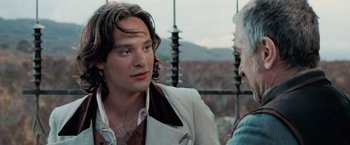 Movie still from “Stardust” (2007), directed by Matthew Vaughn – A man with long hair and a white jacket is talking to another man; Close Up shot, Over the shoulder angle