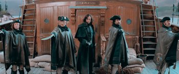 Movie still from “Stardust” (2007), directed by Matthew Vaughn – A group of men standing next to each other in front of a door; Wide shot, Low angle