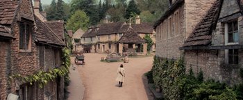 Movie still from “Stardust” (2007), directed by Matthew Vaughn – A woman is walking down the street of a village; Extreme Wide shot, High angle