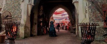 Movie still from “Stardust” (2007), directed by Matthew Vaughn – A woman in a long dress walking down a street; Wide shot, Low angle